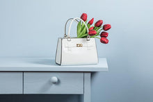 Load image into Gallery viewer, Handbag-shaped ceramic vase with faux leather handle and chic hardware-style detail, available in white, black, and pink