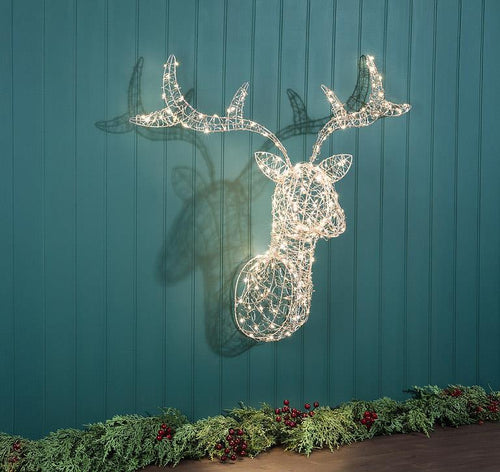Light-up stag head wall sculpture with 250 warm white micro LED lights glowing on a teal paneled wall