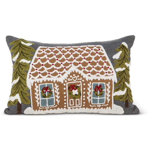 Rectangular tufted lumbar pillow featuring a gingerbread house with snowy trees on a charcoal background