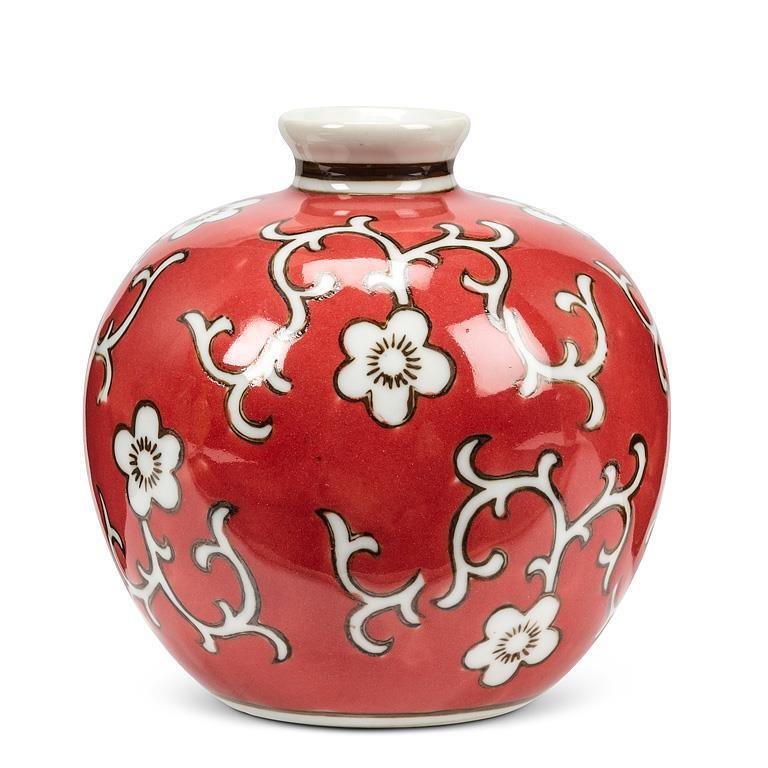 Small round ceramic floral ball vase with a glossy red and brown finish, styled as shelf or tabletop